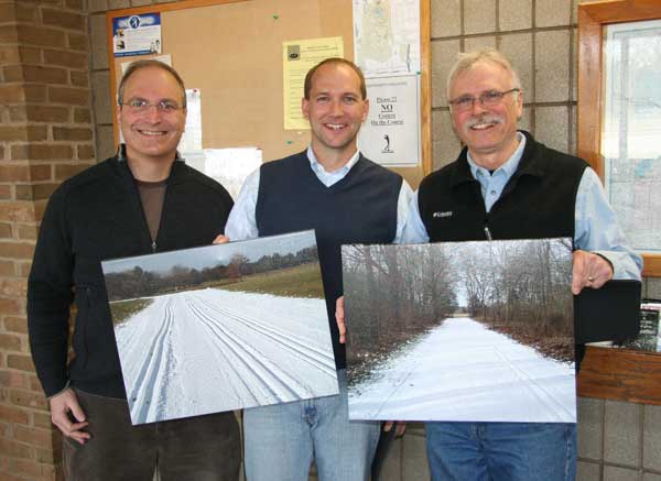 Ken Roth presents custom photos of the Huron Meadows cross country ski trails to Adam Haberkorn and Bill McConnell