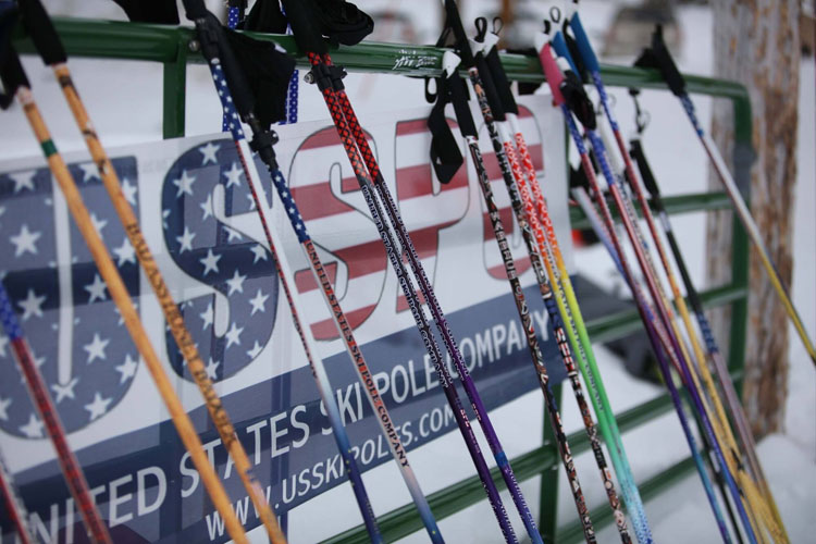 United States Ski Pole Company poles leaning against an outdoor green metal fence