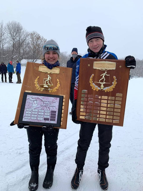 Jean Arielle and William Haapala hold State Championship trophies for the 2021 Michigan State HS XC Ski Championships