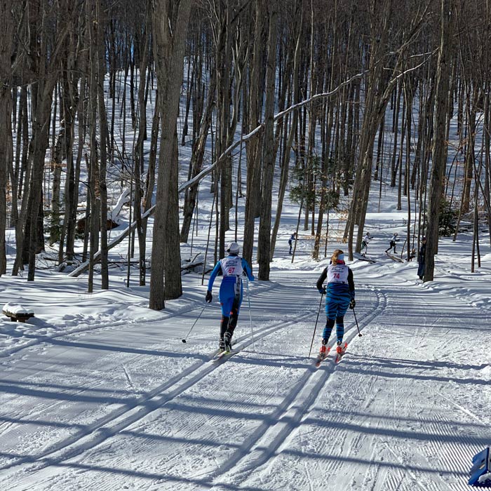 cross country skiers racing up a hill at Hickory Hills in Traverse City, MI