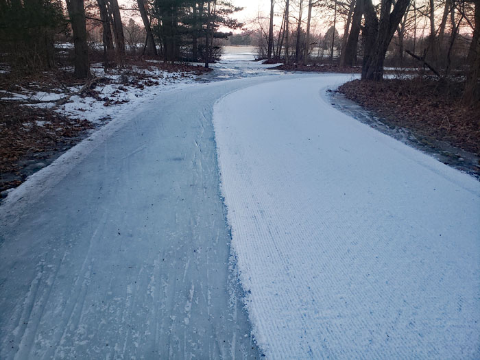Muller snow groomer grooms ice (right side of trail) into snow (left side of trail)